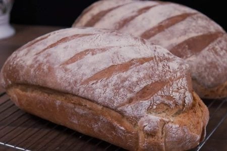 Επειδή δεν έχετε όλοι Γάστρα και μου ζητήσατε μια εύκολη συνταγή για ψωμί σας έχω την τέλεια συνταγή για το πιο εύκολο χωριάτικο ψωμί χωρίς ζύμωμα!!!

Υλικά
1 κιλό αλεύρι Γ.Ο.Χ
625 γρ νερό
9 γρ ξηρή μαγιά
1 κτσ αλάτι
1 κτσ ζάχαρη
2 κτσ ελαιόλαδο
ταψί=25χ30
Εκτέλεση
Ξεκινάμε την συνταγή ρίχνοντας σε ένα μπολ το χλιαρό νερό μαζί με την μαγιά και ανακατεύουμε μέχρι να λιώσει καλά.
Συνεχίζουμε και ρίχνουμε μέσα στο αλεύρι το αλάτι και την ζάχαρη και το προσθέτουμε  μέσα στο νερό.Ρίχνουμε και το ελαιόλαδο και αφού το ανακατέψουμε με μια ξύλινη κουτάλα το αφήνουμε να φουσκώσει σε ζεστό μέρος για περίπου 2 ώρες.
Αφού έχει φουσκώσει καλά χωρίζουμε την ζύμη στα 2 και την διπλώνουμε.Σε ένα ταψάκι 25χ30 τοποθετούμε μια λαδόκολλα αφού την έχουμε διπλώσει στην μέση και βάζουμε τα ζυμάρια έτσι ώστε να μην ακουμπάει το ένα με το άλλο.
Πασπαλίζουμε αλεύρι πάνω απο τις ζύμες και τις χαράζουμε.
Στην συνέχεια σκεπάζουμε με μια πετσέτα και τα αφήνουμε να φουσκώσουν για 1/2 ώρα ακόμη.
Μόλις φουσκώσουν τα ψήνουμε σε προθερμασμένο φούρνο στον αέρα για 50-60 λεπτά στους 200 c
Mόλις ψηθούν τα αφήνουμε να κρυώσουν πριν τα κόψουμε.
Τα ψωμάκια μας έιναι έτοιμα τόσο τραγανά από έξω και αφράτα από μέσα που θα κάνουμε καθημερινά το δικό μας ψωμί.Ένα πεντανόστιμο Παραδοσιακό Χωριάτικο ψωμί χωρίς γάστρα που θα το λατρέψετε..
Καλή σας επιτυχία!!!