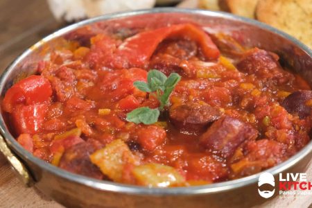 ?500 γρ μοσχαρίσια καπνιστά λουκάνικα
?1 μέτριο κρεμμύδι
?2 κόκκινες πιπεριές
?1 πράσινη πιπεριά
?1 καυτερή πιπεριά
?100 γρ ντοματίνια
?1 σκελίδα σκόρδου
?40 γρ ελαιόλαδο
?70 γρ λευκό κρασί
?1 κτγ πελτέ ντομάτας
?400 γρ ντομάτα κονκασέ
?150 γρ νερό
?Ανθός αλατιού
?Ρίγανη
----------------------------------------
?4-5 φέτες ψωμί
?Ελαιόλαδο
?Ρίγανη